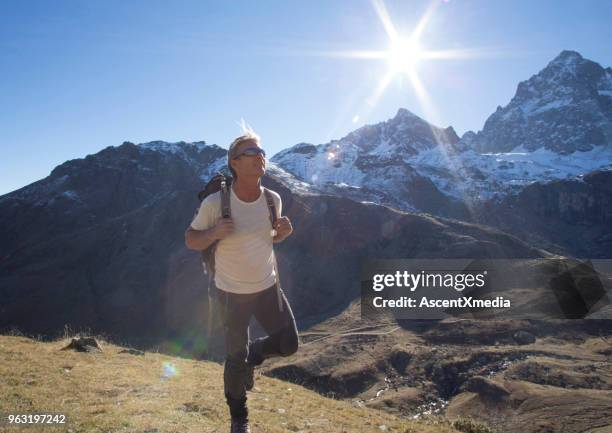 männliche wanderer treks durch berge in der sonne - cuneo stock-fotos und bilder