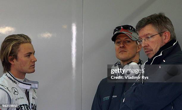 Nico Rosberg and Michael Schumacher of Germany and Mercedes speak with their team principal Ross Brawn in their garage at the Ricardo Tormo Circuit...