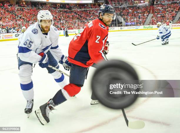 Washington Capitals defenseman Matt Niskanen and Tampa Bay Lightning defenseman Braydon Coburn go after a loose puck off the glass in the third...