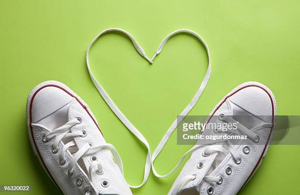 blanco zapatillas en amor - zapato de tela fotografías e imágenes de stock