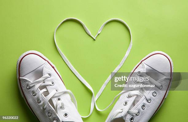 white sneakers in love - green shoes stockfoto's en -beelden