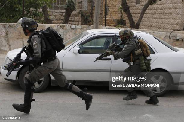 Israeli troops run during clashes with Palestinian youth in the Amari refugee camp near Ramallah in the occupied West Bank after they stormed the...