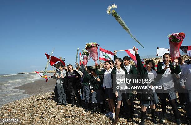 Lebanese schoolgirls throw flowers into the sea during a memorial ceremony for the victims of the Ethiopian airliner that crashed off Lebanon, in...