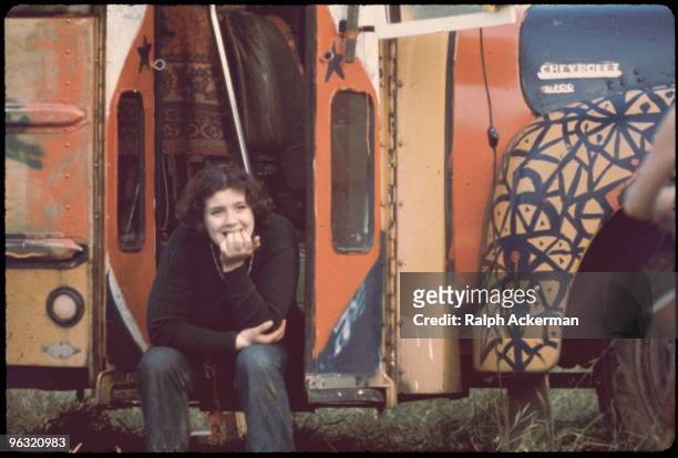 Merry Prankster girl sits in stairwell of handpainted bus, at the Woodstock music festival, August 1969.