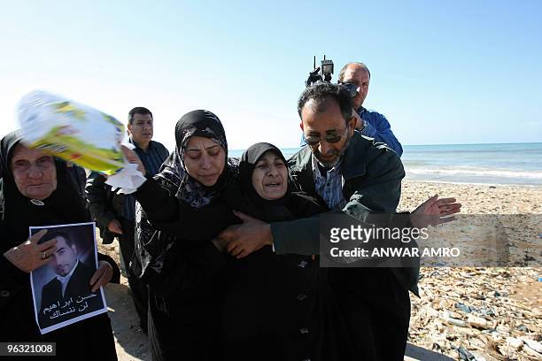 The mother of Lebanese Hassan Ibrahim, who was aboard the Ethiopian airliner that crashed off Lebanon, is comforted by relatives as she walks on the...