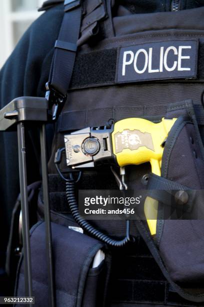 rückansicht des bewaffneten polizisten in london uk - betäubungsgewehr stock-fotos und bilder