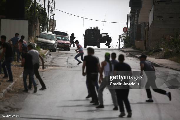 Palestinians throw rocks in response to Israeli soldiers' invasion at Al-Amari Refugee Camp in Ramallah, West Bank on May 28, 2018. According to...