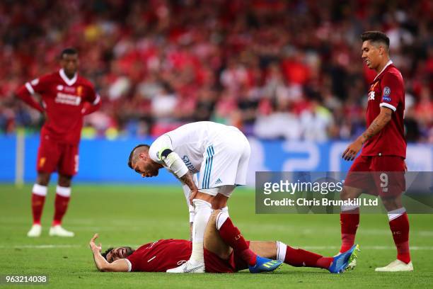 Mohamed Salah of Liverpool lies injured as Sergio Ramos of Real Madrid looks on during the UEFA Champions League final between Real Madrid and...