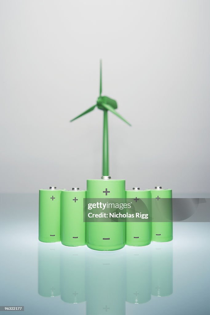 Batteries with wind turbine in the background