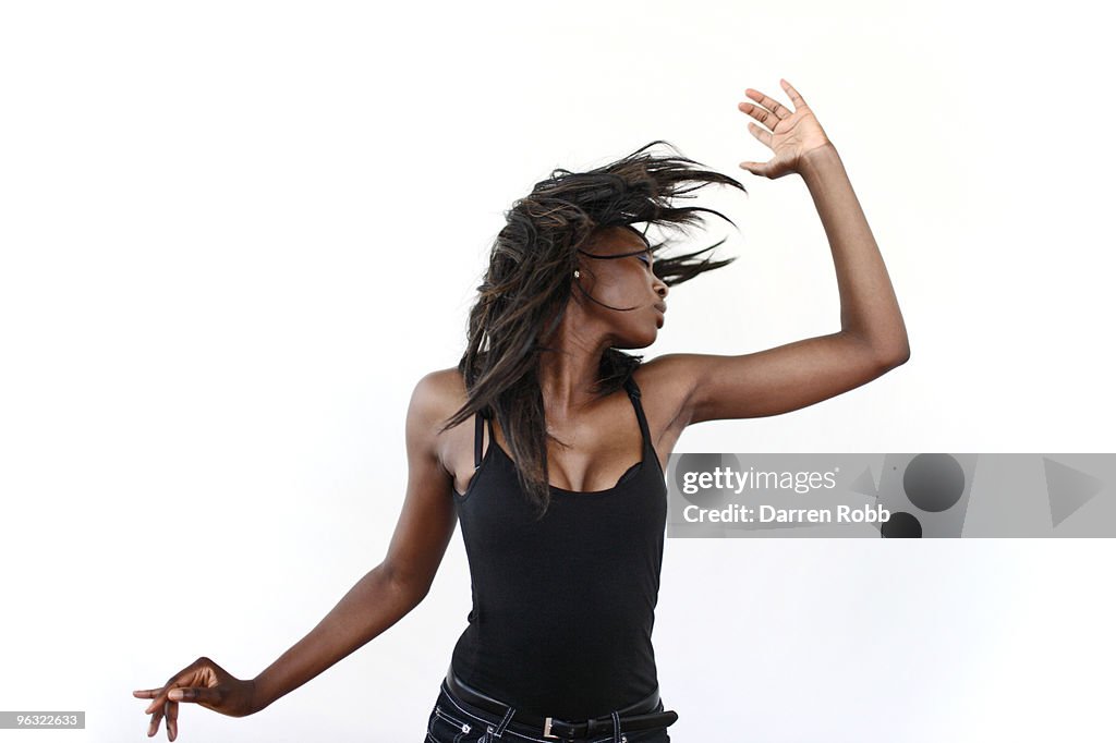 Young woman dancing and shaking her hair