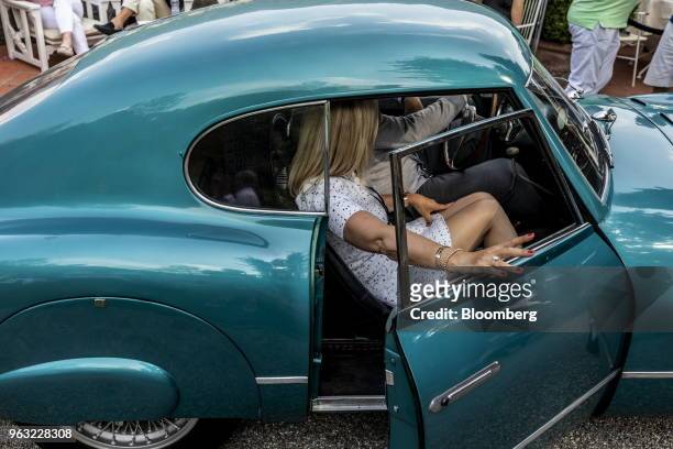 Entrant Manfred Schweri and a guest sit inside a 1954 Fiat Chrysler Automobiles NV 8V automobile at the 2018 Concorso D'Eleganza at Villa d'Este in...