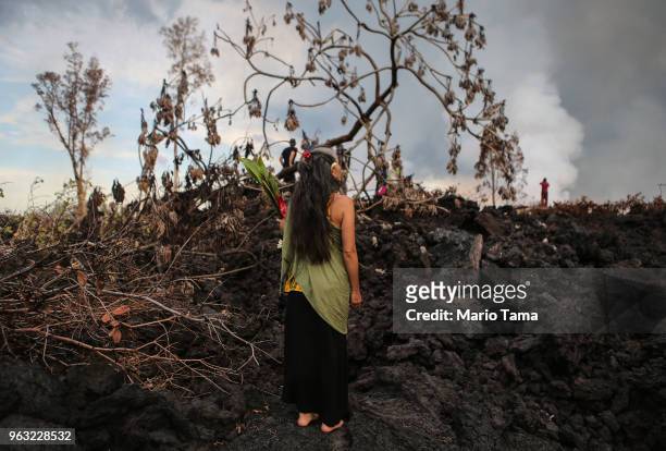 Traditional hula practitioner holds an offering on a recent lava flow from a Kilauea volcano fissure, on Hawaii's Big Island, on May 27, 2018 in...