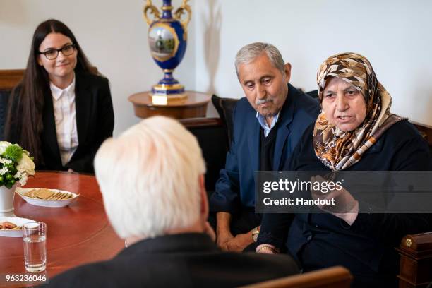 In this handout photo provided by the Federal President Frank-Walter Steinmeier talks to Mevlude Genc , who lost two daughters, two granddaughters...