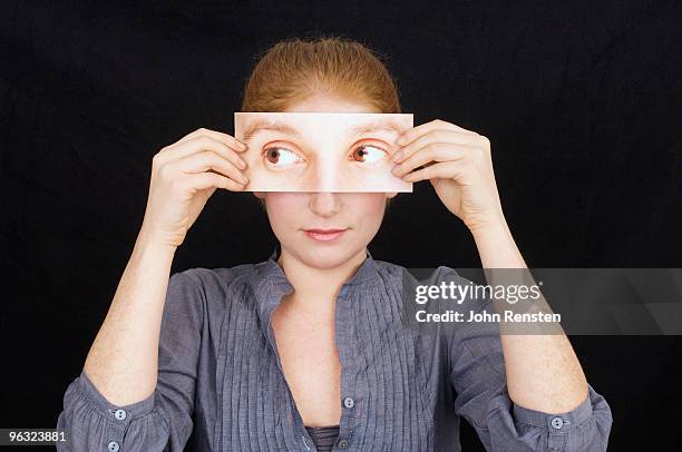 girl hiding behind paper mask with false eyes - mask disguise stockfoto's en -beelden