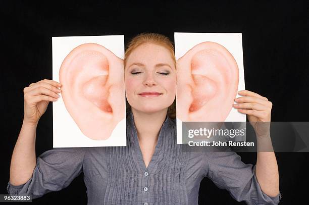 girl smiling and listening with huge comedy ears - human ear stockfoto's en -beelden