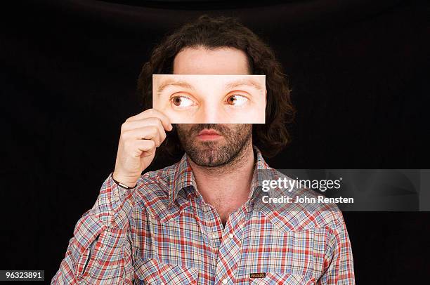 man hiding behind paper mask with false eyes  - hidden identity stock pictures, royalty-free photos & images