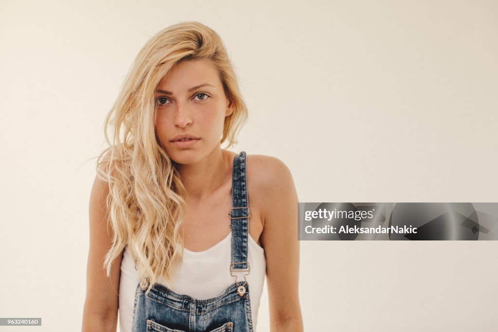 Portrait of a cute blonde girl wearing overalls