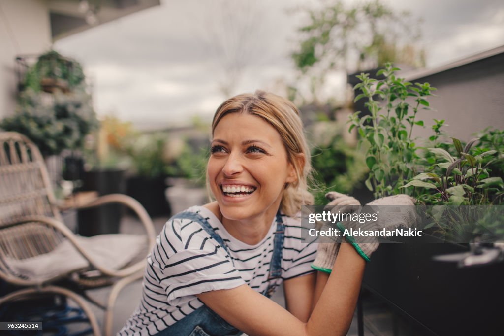 Junge Frau, die Vermittlung von Pflanzen in ihrem Dachgarten auf dem