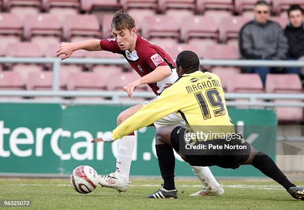 John Johnson of Northampton Town looks to move past the challenge of Jacques Maghoma of Burton Albion during the Coca Cola League Two Match between...