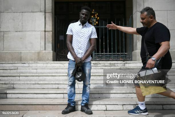 Passer by arrives to take a selfie with a 22-year old Mamoudou Gassama from Mali in front of the townhall of Montreuil, eastern Paris suburb, on May...