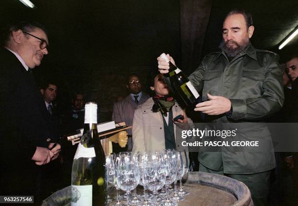 Cuban President Fidel Castro looks at a bottle of Chablis in a Burgundy cellar, during his visit to this wine producing area, 16 March 1995 in...