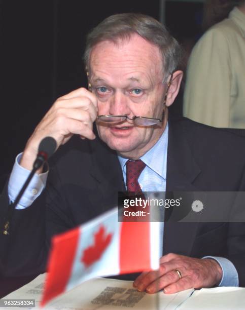 Canadian Prime Minister Jean Chretien adjusts his glasses as he reads through documents before the start of the second executive session of the...
