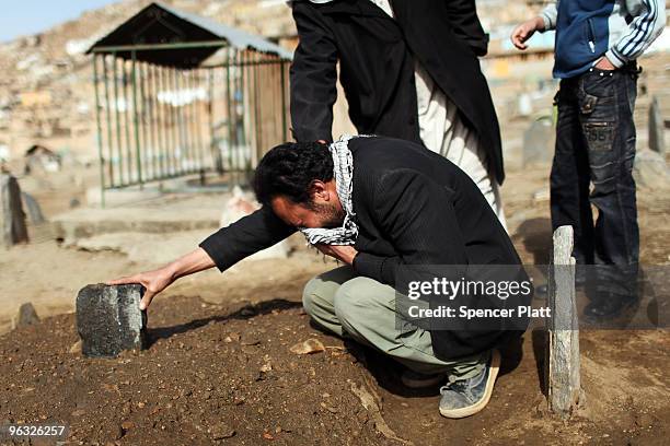 Amin Haidary grieves at the grave of his son Hamid who he said recently died from an illness that was not brought to a doctor's attention quickly...