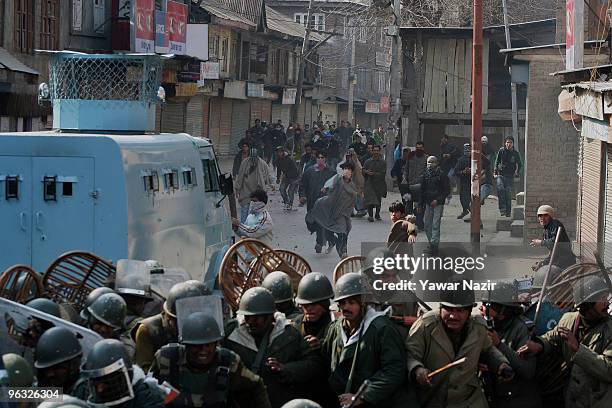 Kashmiri protesters chase and throw stones at Indian police during a protest against the death of a 14 years old teenager, Wamiq Farooq on February...