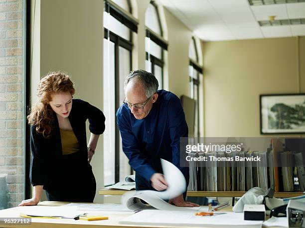 businesswoman and businessman examining plans - leanintogether stock pictures, royalty-free photos & images