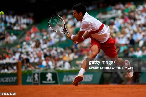 Serbia's Novak Djokovic plays a return to Brazil's Rogerio Dutra Silva during their men's singles first round match on day two of The Roland Garros...