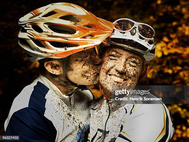 happy mud covered mountain bikers kissing - extreme sports bike stock pictures, royalty-free photos & images