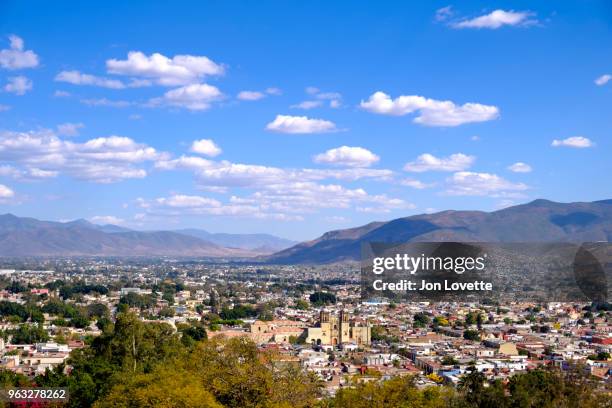 high view of skyline of oaxaca city with surrounding mountains and santo domingo church - santo domingo church stock pictures, royalty-free photos & images