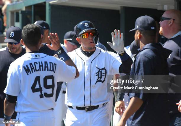 Miguel Cabrera of the Detroit Tigers gets high-fives from teammates in the dugout during game one of a doubleheader against the Kansas City Royals at...