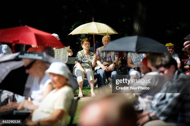 People are seen attending one of the regular, free Chopin open air concerts in the Royal Baths park in Warsaw, Poland on May 27, 2018. During the...