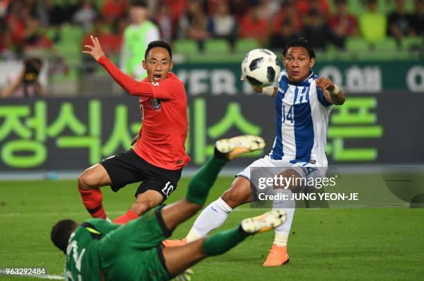 South Korea's Moon Seon-min and Honduras' Carlos Sanchez look on as Honduras goalkeeper Donis Escober tries to block the ball during a friendly...