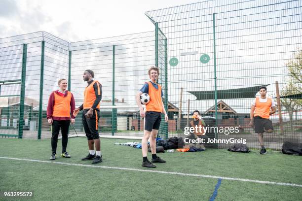 fünf fußball-spieler auf der seitenlinie in fußball-lätzchen im chat und ruhen - amateur stock-fotos und bilder