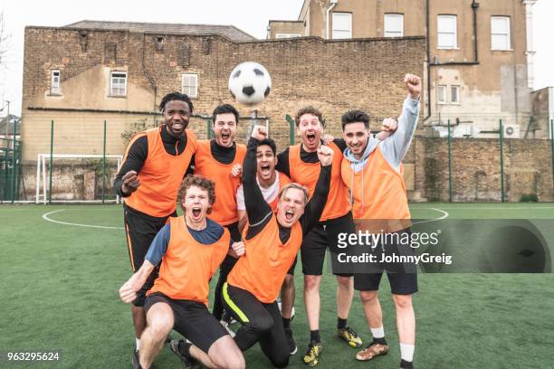 seven a side football team cheering with ball in the air - soccer team stock pictures, royalty-free photos & images
