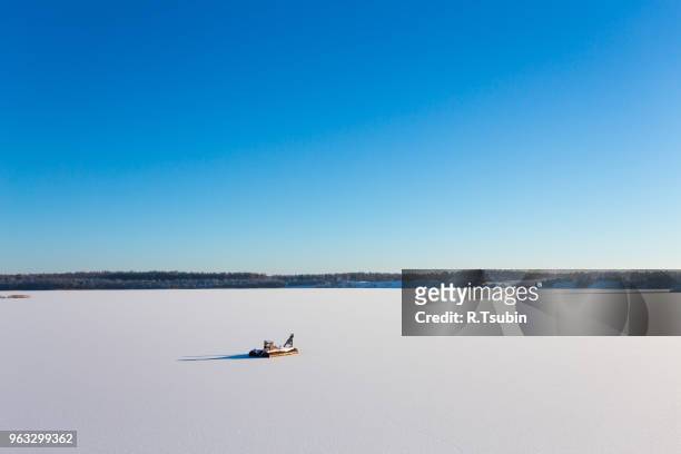 frozen lake with ice and snow, sunny winter day. forest - february stockfoto's en -beelden