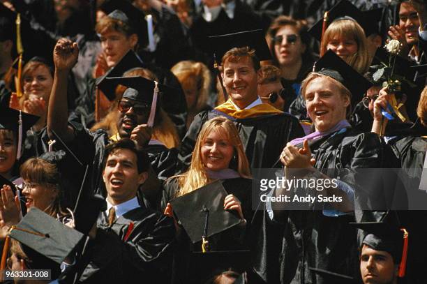 crowd of graduates wearing graduation caps and growns - graduation crowd stock pictures, royalty-free photos & images