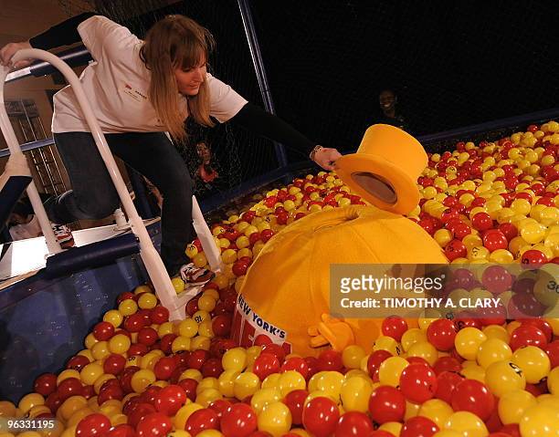 Employee looks for a man in a mascot suit after he falls in a ball pit set up in Grand Central Station in New York on February 1, 2010 to promote the...