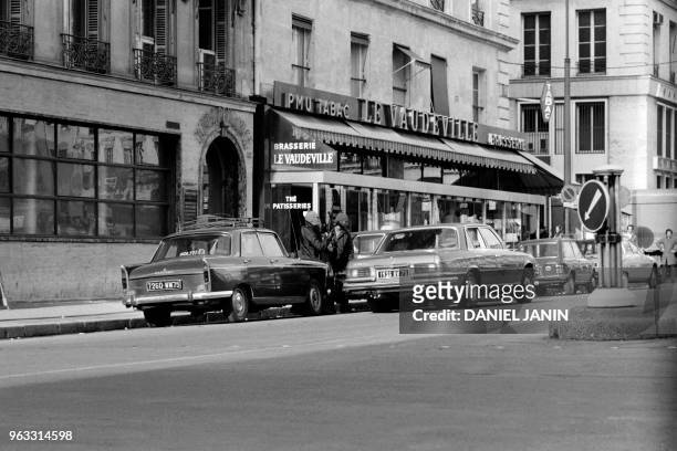 Gangsters flee with one of their three hostages aboard a Mercedes 450 after a robbery at Crédit de la Bourse bank on January 31, 1974 on Place de la...