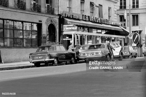 Gangsters flee with one of their three hostages aboard a Mercedes 450 after a robbery at Crédit de la Bourse bank on January 31, 1974 on Place de la...