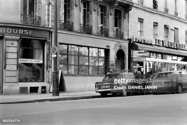 Gangsters wait for one of them before fleeing with one of their three hostages aboard a Mercedes 450 after a robbery at Crédit de la Bourse bank on...