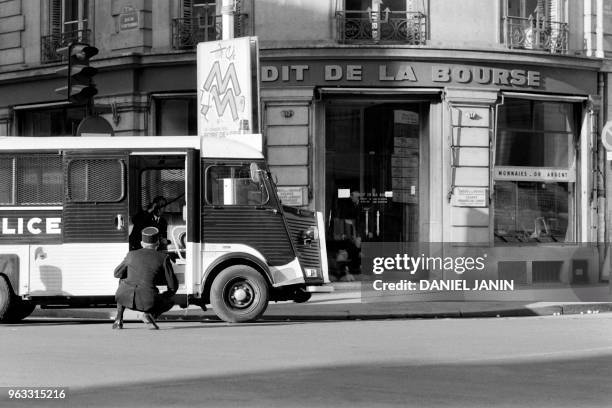 Policemen stand guard in front of the Credit de la Bourse bank during a robbery, on January 31, 1974 on Place de la Bourse in Paris. Les policiers...