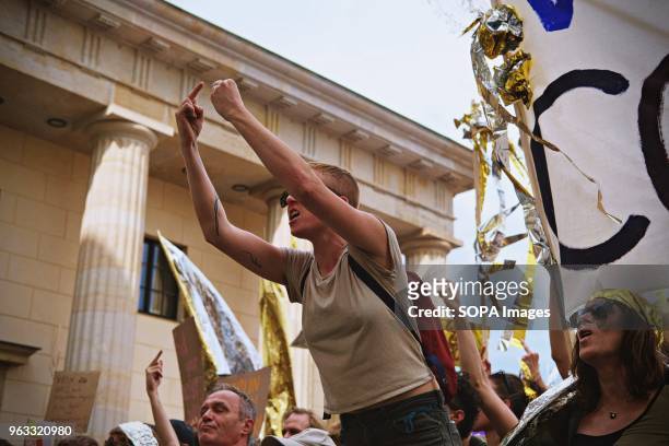 Woman seen giving the middle finger during the demonstration. Techno lovers and anti racism activists have marched in Berlin against a rally...
