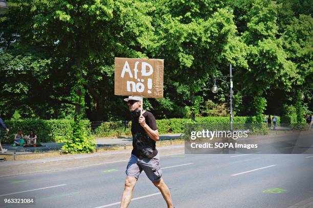 Demonstrators seen walking while holding a placard saying 'AFD no !' during the demonstration. Techno lovers and anti racism activists have marched...