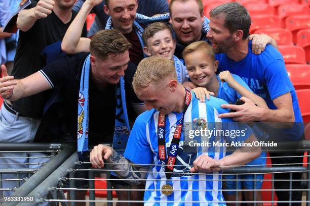 Jack Grimmer of Coventry City appears to get stuck between metal wires after celebrating with the fans during the Sky Bet League Two Play Off Final...