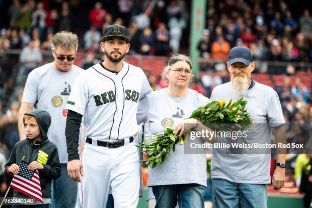 Blake Swihart of the Boston Red Sox escorts a gold star family in a ceremony in recognition of Memorial Day before a game against the Toronto Blue...