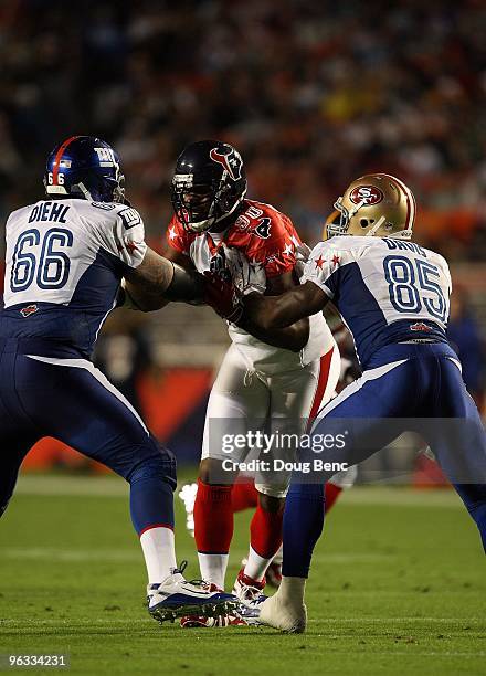 Mario Williams of the Houston Texans in action against David Diehl of the New York Giants and Vernon Davis of the San Francisco 49ners during the...