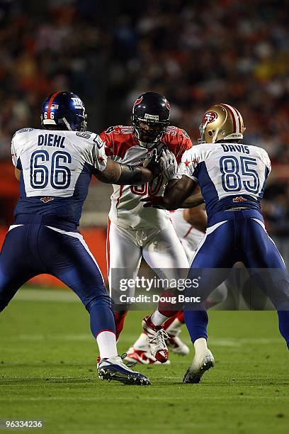 Mario Williams of the Houston Texans in action against David Diehl of the New York Giants and Vernon Davis of the San Francisco 49ners during the...